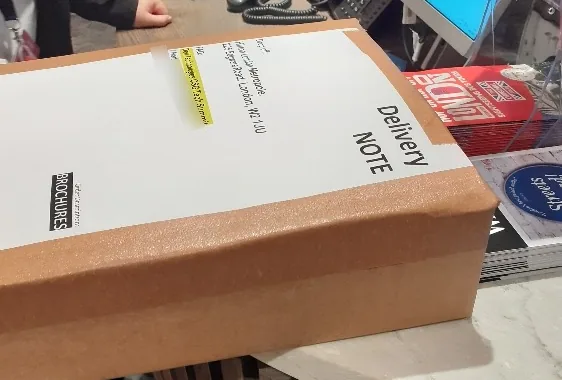 Boxed NVIDIA GB300 conference flyers with a delivery note on the reception desk of the Hilton London Metropole, the label addressed to the Dell Technologies tech summit