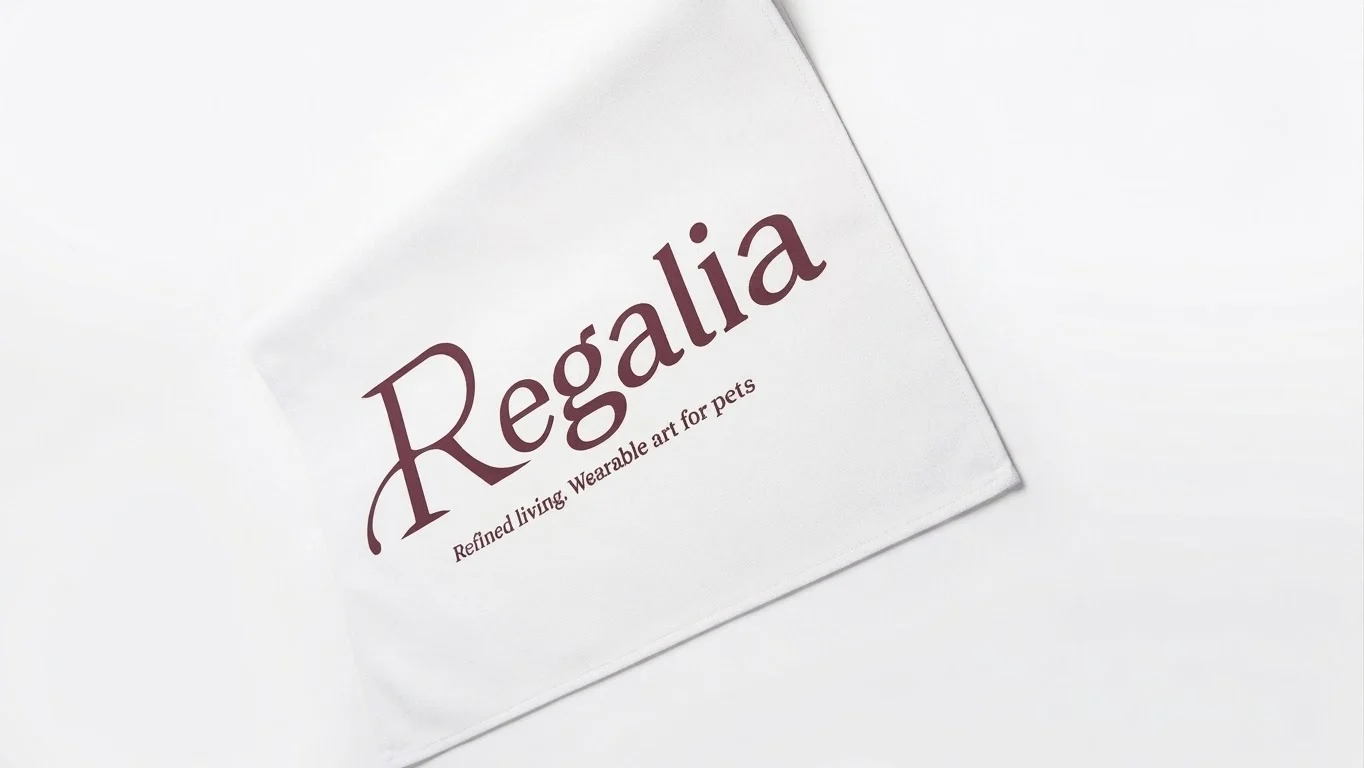 Printed white canvas table runner with the Regalia logo and the line "Refined living. Wearable art for pets", laid flat before delivery