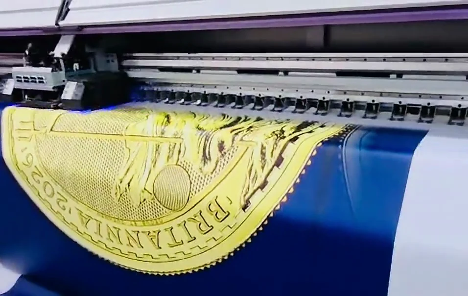 Gold bullion coin artwork almost fully printed on the wide-format printer during production of a 7 m scaffold banner