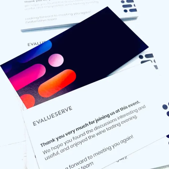 Evalueserve event thank-you cards fanned out, one turned to show a dark gradient reverse