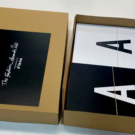 Black and kraft presentation box holding printed invitation cards