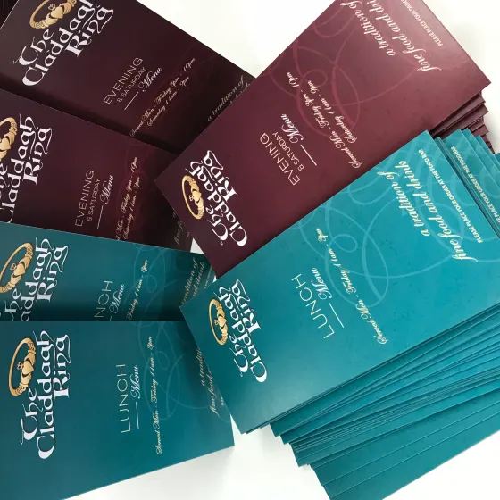 Stacks of folded burgundy and teal event menu cards