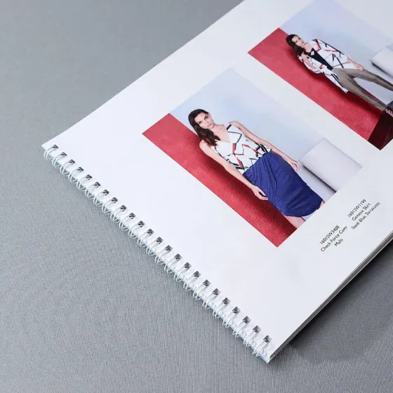 Wire bound fashion lookbook opened flat, showing model photography and product codes