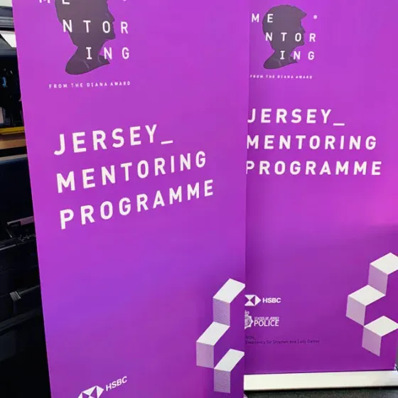 Two purple Diana Award Jersey Mentoring Programme roller banners standing side by side