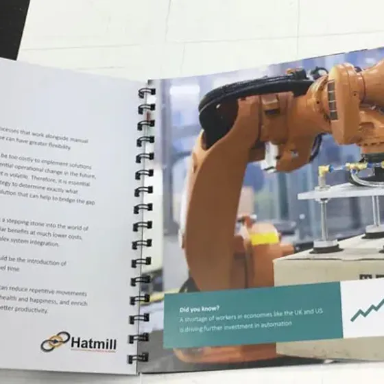 Wire bound Hatmill report opened flat, a warehouse robot photograph running across the spread