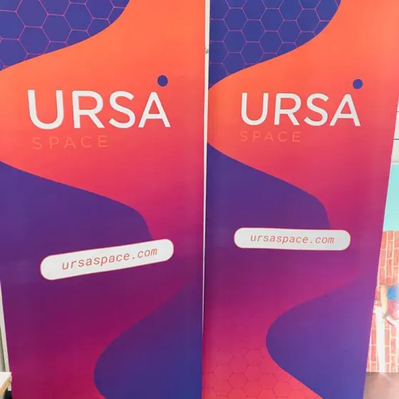 Two matching magenta and blue Ursa roller banners standing side by side