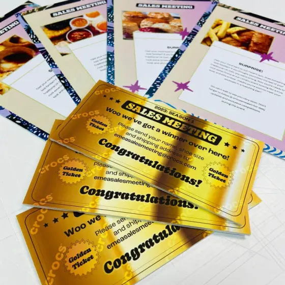 Gold and colour printed certificates and vouchers fanned across a surface