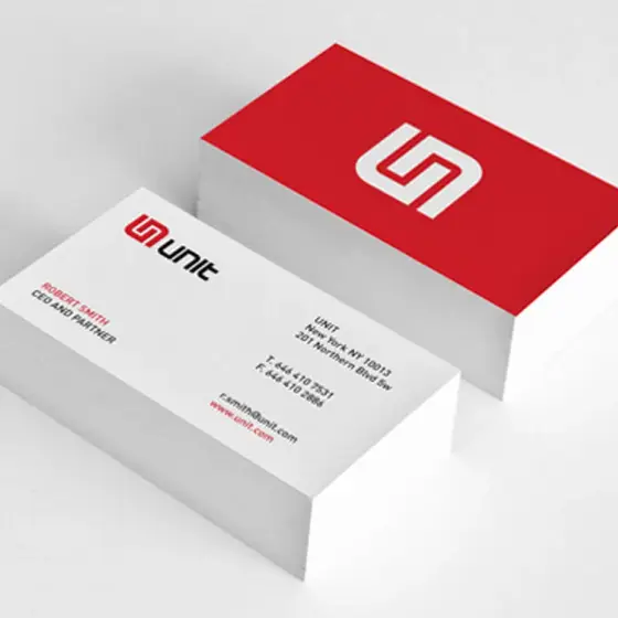 Two stacks of business cards, one red and one white, printed on uncoated board