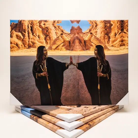 A stretched canvas standing upright with more finished canvases stacked flat in front of it