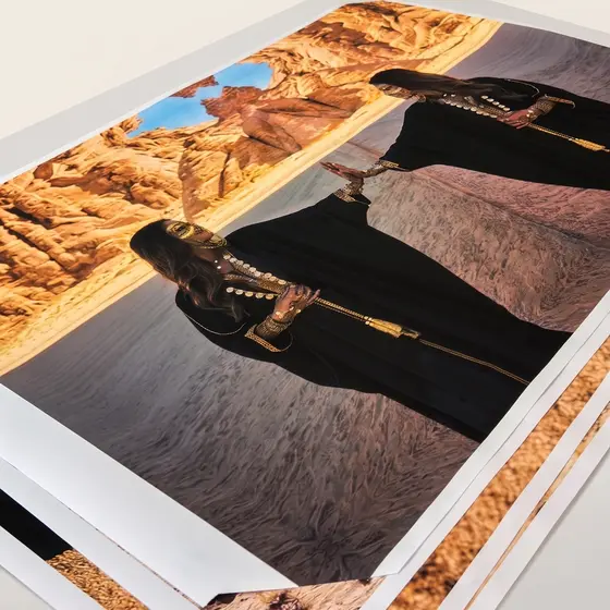 A photographic print lying at an angle on a white surface, a desert landscape visible