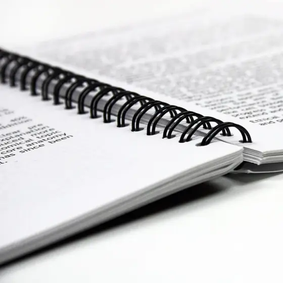 Black wire binding on a printed document, opened flat.