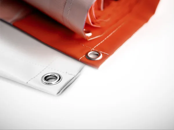 Close-up of a rolled PVC banner showing a metal eyelet set into the hemmed edge