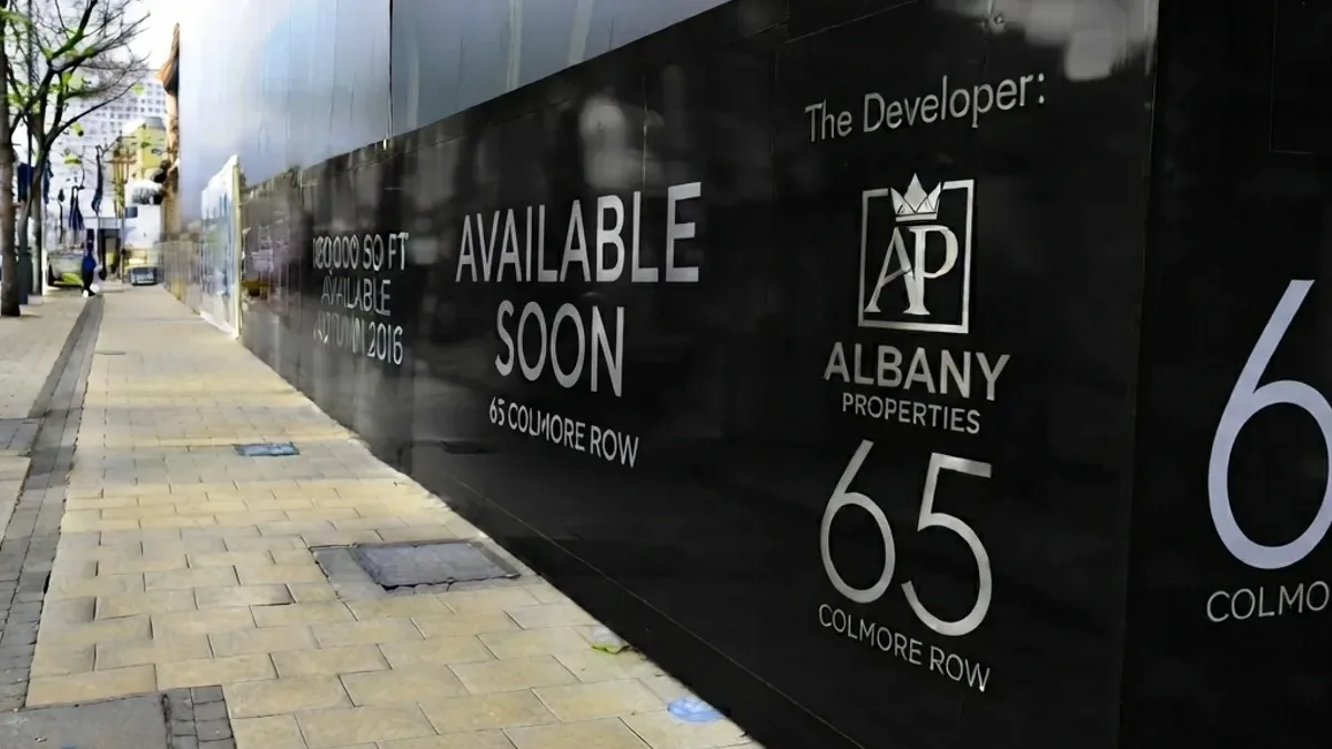 Printed construction hoarding running along a development frontage at street level