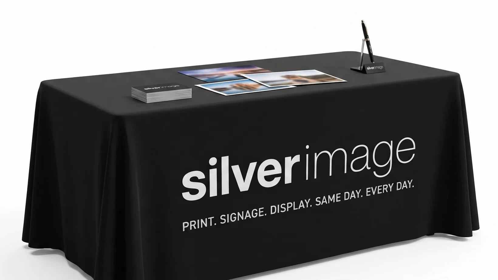 Printed tablecloth fitted over an exhibition table, branded across the front drop