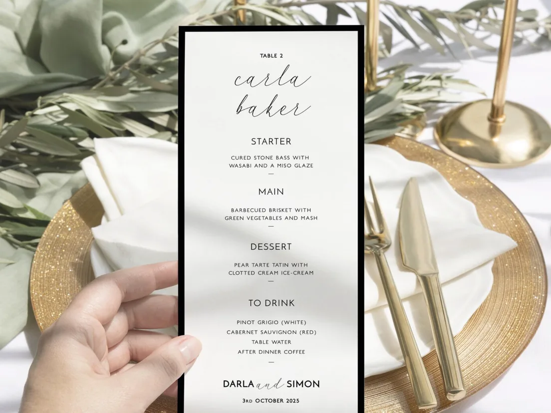 Menu card held above a laid place setting with gold cutlery