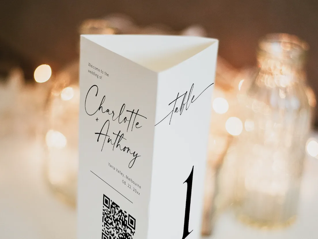 Folded tent menu standing upright on a table among lit candles