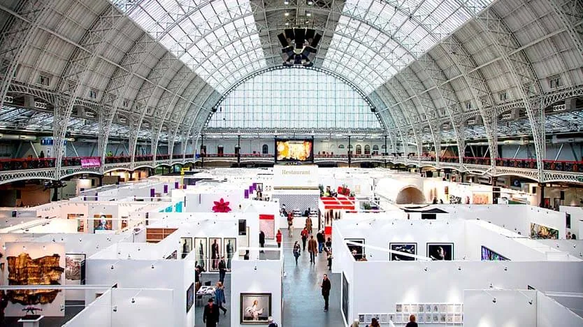 Exhibition hall in London filled with stands and framed large format prints