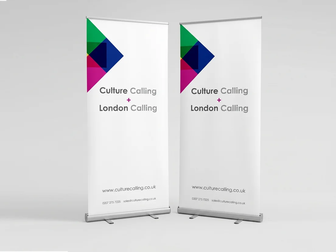 Two white roller banners with a coloured geometric mark, web address and contact line at the base