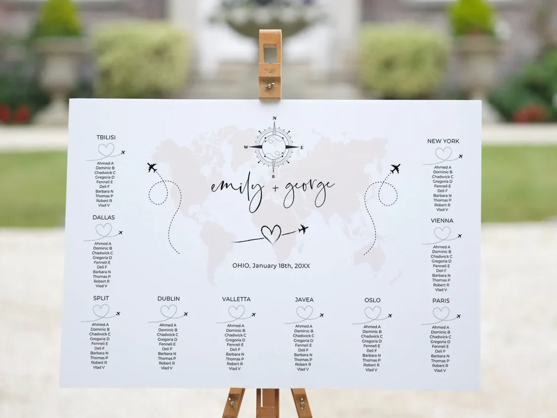 Seating plan on a gold easel outdoors at a venue entrance, greenery behind